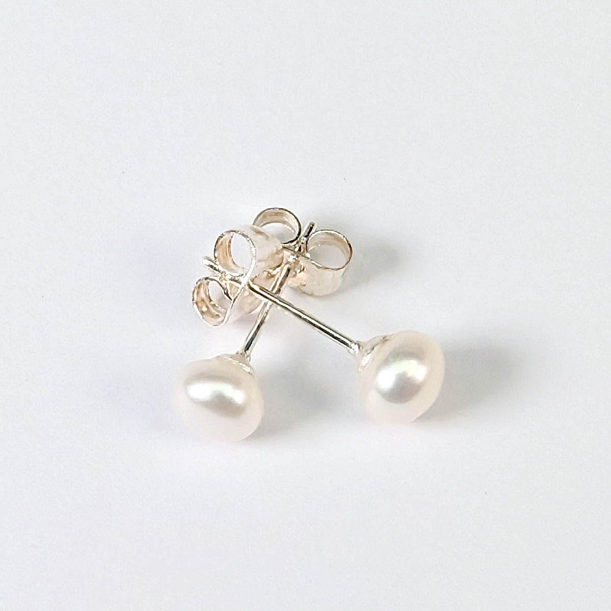 Boucle d'oreille clou Diana en argent 925 avec perle de culture blanche en forme de bouton, environ 5mm, nacrée, posée sur fond blanc