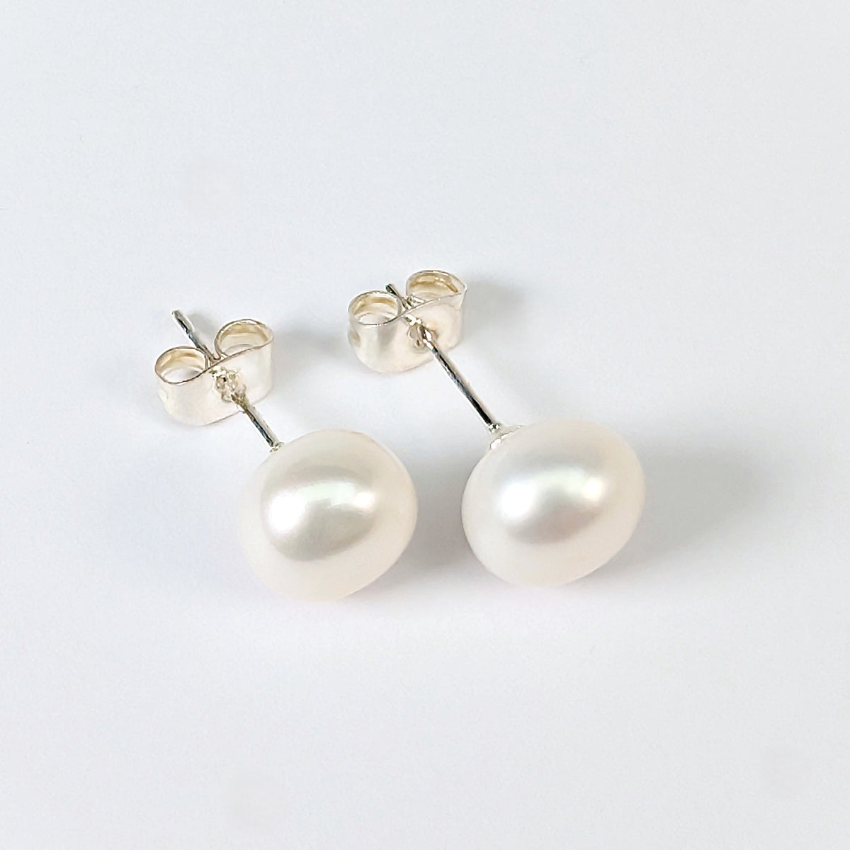 Boucle d'oreille clou Diana en argent 925 avec perle de culture blanche en forme de bouton, environ 9mm, nacrée, posée sur fond blanc