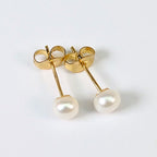 Boucle d'oreille clou Diana en plaqué or 18K avec perle de culture blanche en forme de bouton, environ 5mm, nacrée, posée sur fond blanc