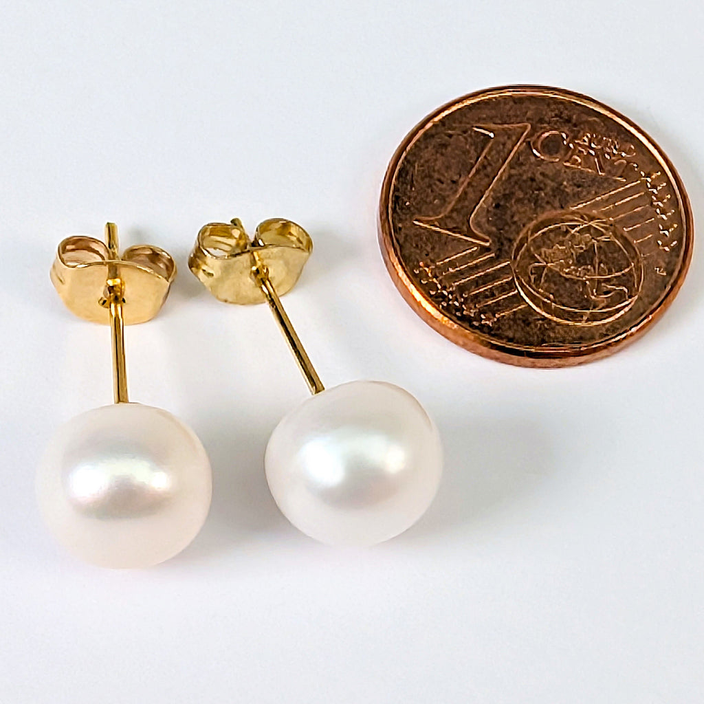 Boucles d'oreilles Diana en perle de culture blanche 8mm, monture plaquée or 18K, mis a l'échelle face a une pièce de 1 centime
