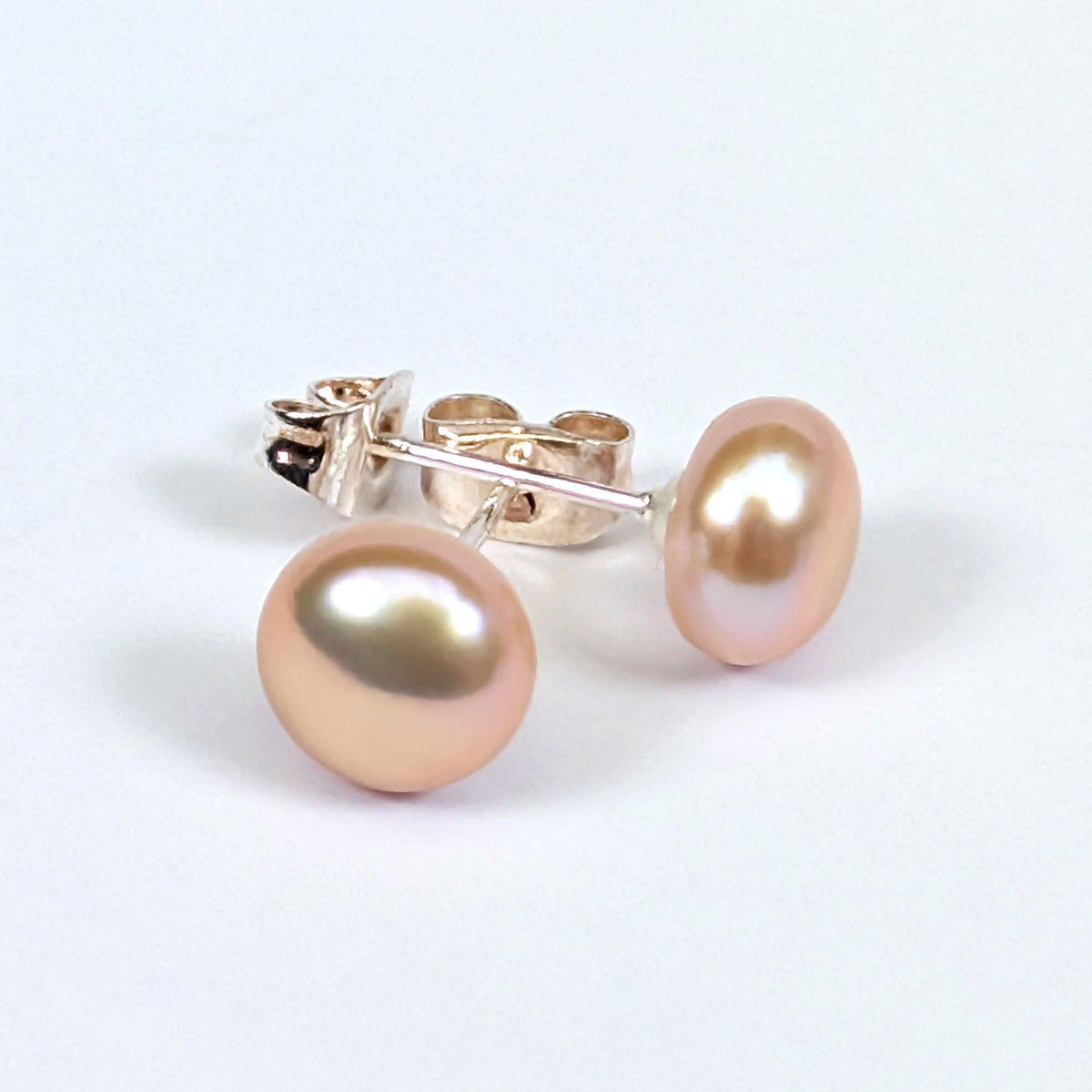Boucle d'oreille clou Diana en argent 925 avec perle de culture rose pâle en forme de bouton, environ 7mm, nacrée, posée sur fond blanc