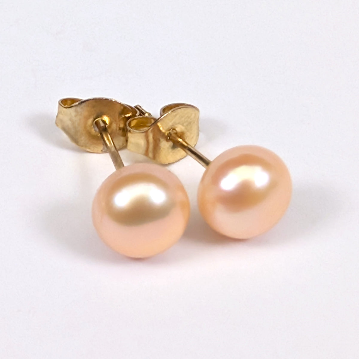 Boucle d'oreille clou Diana en plaqué or 18K avec perle de culture rose pâle en forme de bouton, environ 6mm, nacrée, posée sur fond blanc