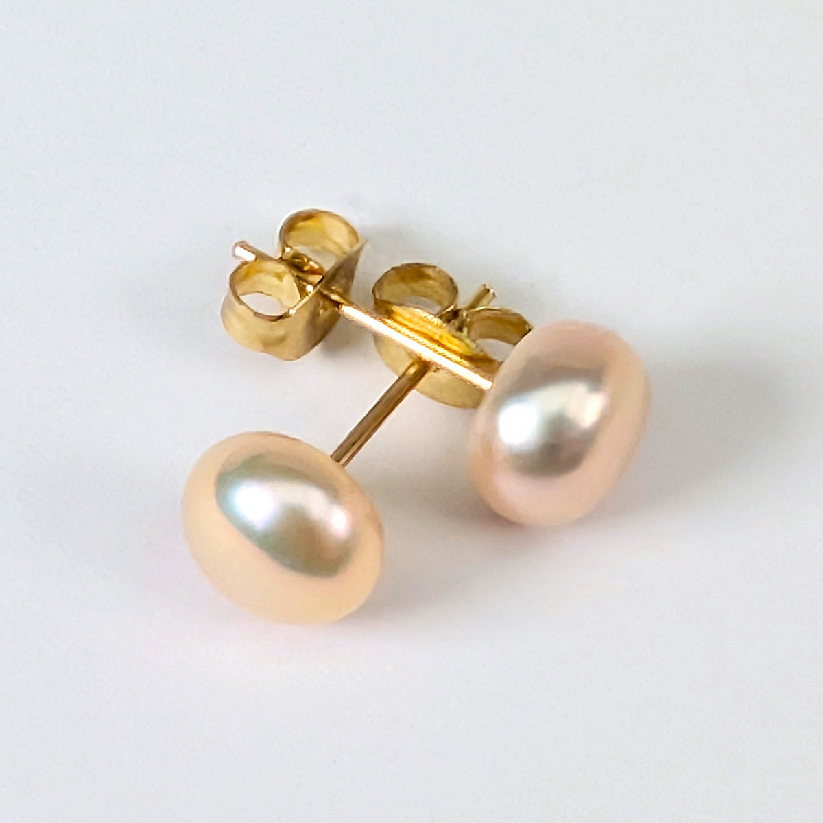 Boucle d'oreille clou Diana en plaqué or 18K avec perle de culture rose pâle en forme de bouton, environ 7mm, nacrée, posée sur fond blanc