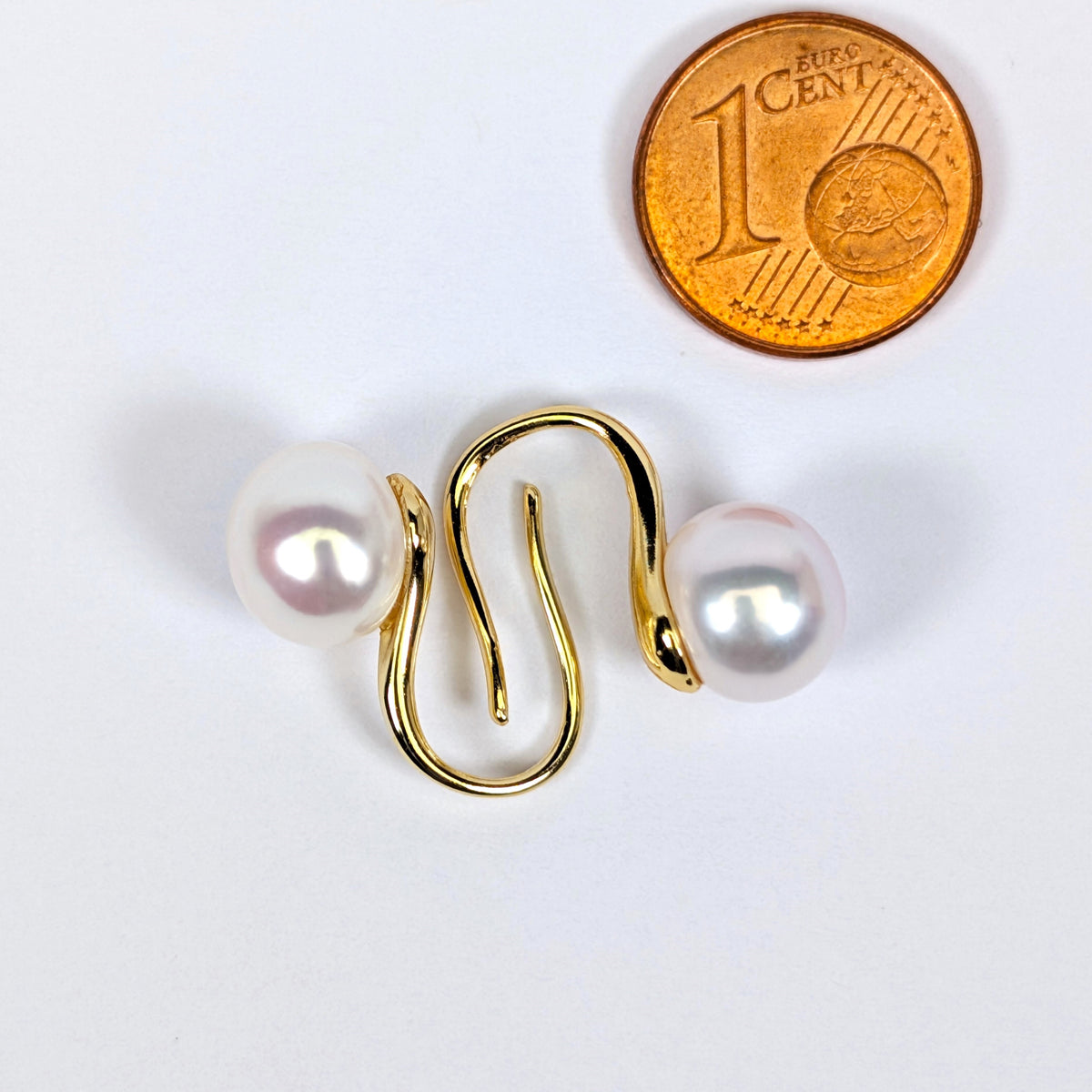 Boucles d'oreilles Cléopâtre à côté d'une pièce d'1 centime pour comparaison de taille, perle de culture blanche en forme de bouton