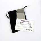 Écrin de présentation L'Atelier de la Perle : pochon en velours noir, certificat d'authenticité manuscrit précisant forme, couleur, taille et qualité de la perle, et pochette de protection transparente